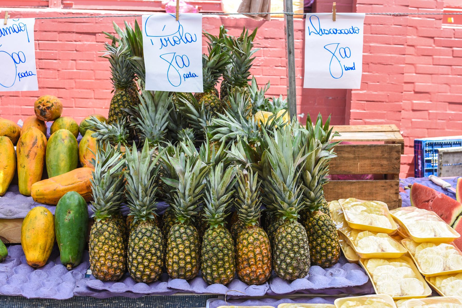Pineapples and papayas stacked on a street market stall